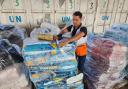 United Nations and Red Crescent workers prepare aid for distribution to Palestinians at an UNRWA warehouse in Deir Al-Balah, Gaza (Hassan Eslaiah/AP)