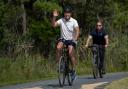 US President Joe Biden rides his bike followed by a Secret Service agent in Delaware (Manuel Balce Ceneta/AP)