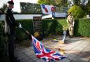 Standard bearers Mr Strachan and S.I. Wong lower the flags