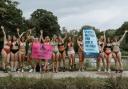 Women wearing bikinis hold up placards as part of the first Bikini March on Hampstead Heath