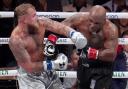 Jake Paul, left, fights Mike Tyson during their heavyweight boxing match in Arlington, Texas (Julio Cortez/AP)