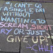 A quote from Child Q, a Black schoolgirl who was strip searched by police, is scrawled into a Hackney pavement