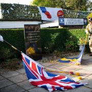 Standard bearers Mr Strachan and S.I. Wong lower the flags