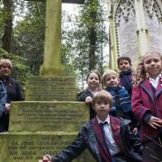 Pupils from Highgate Junior School lay a poppy and cross on the grave of Murray Stuart Pound, a head boy who died in the First World War, at Highgate Cemetery.  Picture: Nigel Sutton