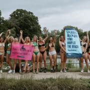 Women wearing bikinis hold up placards as part of the first Bikini March on Hampstead Heath