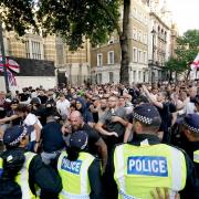 Police officers clash with protesters in Whitehall following the fatal stabbing of three children at a Taylor Swift-themed holiday club in Southport.