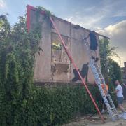 Contractors dismantle a billboard in Cricklewood