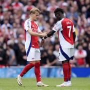 Arsenal's Martin Odegaard (left) gives the captain's armband to Bukayo Saka Image: PA