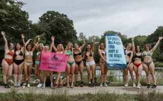 Women wearing bikinis hold up placards as part of the first Bikini March on Hampstead Heath