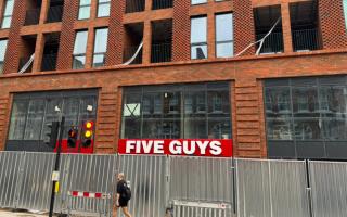 A sign on the front of the upcoming Five Guys burger restaurant in West Hampstead