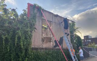 Contractors dismantle a billboard in Cricklewood